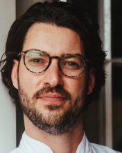 a man wearing glasses and looking at the camera