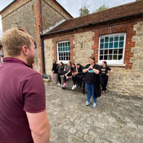 a group of people standing in front of a brick house